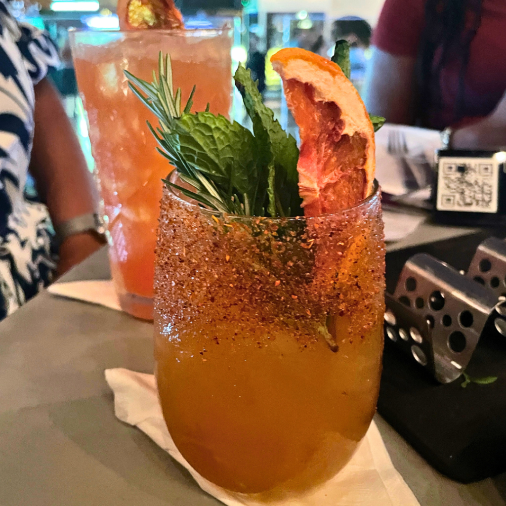 Orange cocktail with rosemary and dehydrate orange peel garnish. 