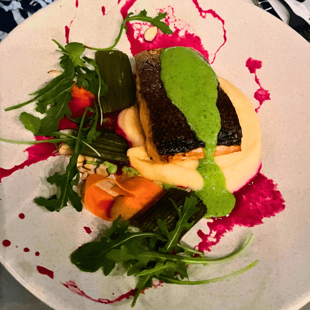 Salmon on bed of vegetables and mashed potatoes.