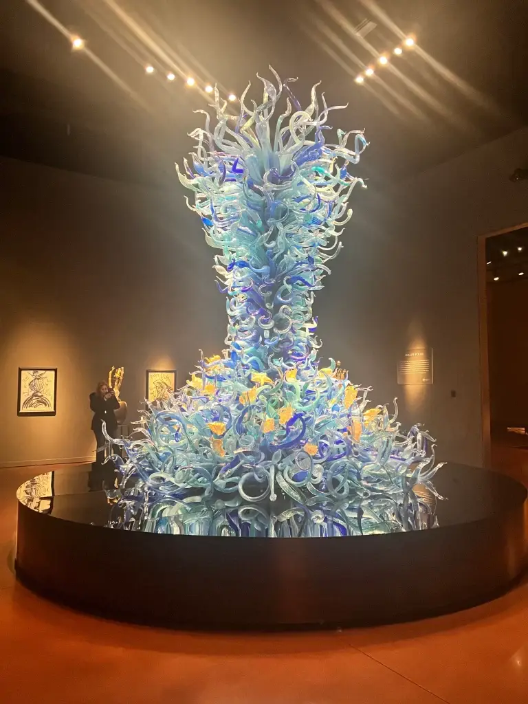 Towering blue blown glass sculpture inside Chihuly Garden and Glass Museum in Seattle