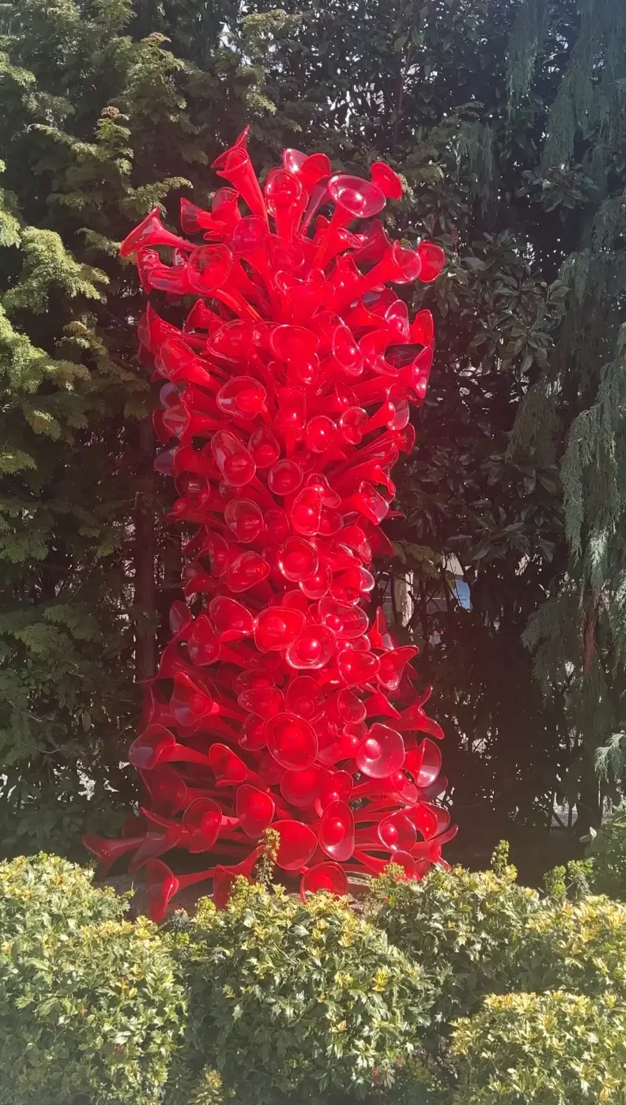 Tall red towering glass structure at Chihuly museum in Seattle.